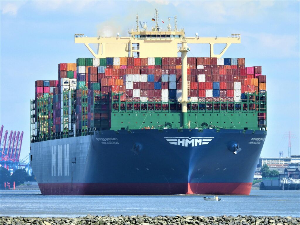Front view of a massive cargo ship loaded with containers in Hamburg's harbor.